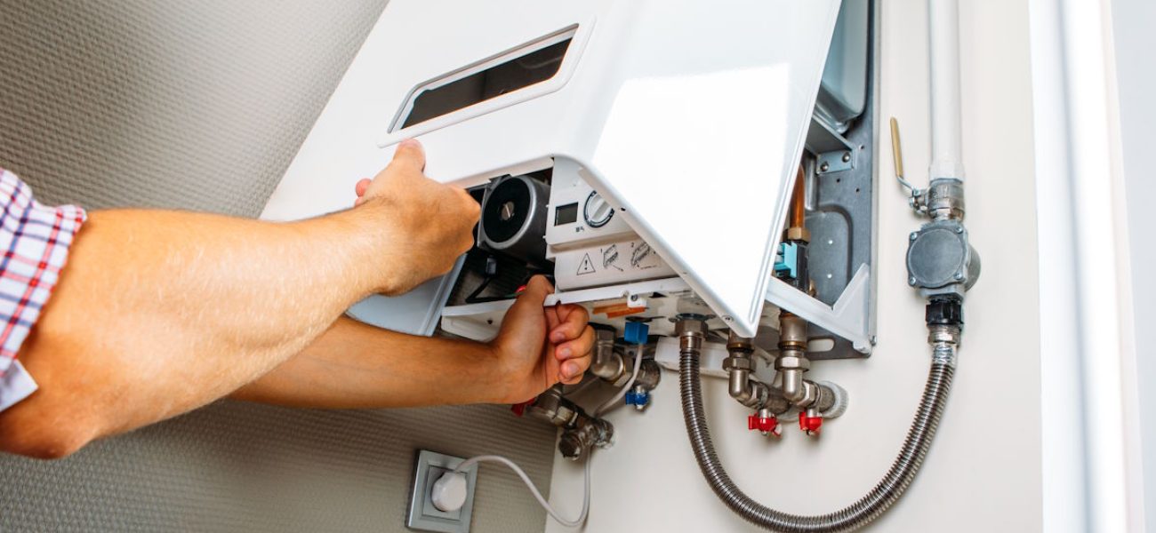 Plumber attaches Trying To Fix the Problem with the Residential Heating Equipment. Repair of a gas boiler